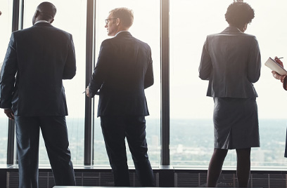 Employees standing at window discussing work