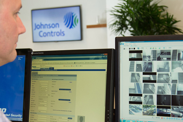 A security officer watching surveillance footage on a monitor