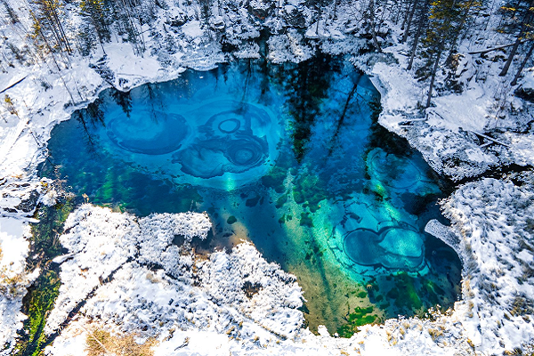 A frozen lake in a snow-covered forest 